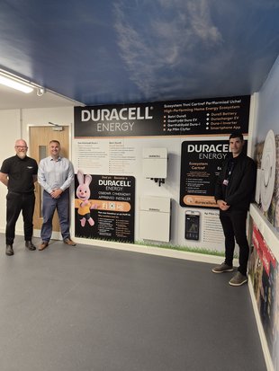 Duracell Energy and Adra representatives standing besides the installation at Tŷ Gwyrddfai
