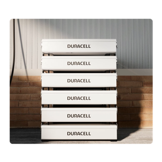 Stack of white battery packs on a floor in a garage